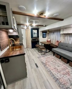 a living room filled with furniture next to a kitchen