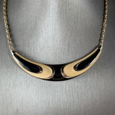 With an Art Deco Revivalist Style this two-point enamel choker by D'Orlan is totally up your alley. Cheeuh! Item: choker necklace - - - Identification: D'Orlan 8785 - - - Style: Art Deco Revival - - - Approximate Date / Era: 1980's - - - Material: brass, enamel decoration - - - Colour(s): gold tone with black and cream enamel - - - Condition: excellent. The clasp has a little wear and no longer brand new and glossy. Dimensions (sizes approximate): medium sized choker - - - Length of chain: 14" (360mm) - - - Width of pendant: 3" (80mm) - - - Height of pendant: 1/2" (15mm) - - - Weight: .9oz. (24g) Inventory Number: NK622 Necklaces & Pendants To view my full selection of Vintage Pendant Necklaces, Chockers, Flapper, Bibs, etc., please link to my "Necklaces & Pendants" collection here: https: Black Enamel Metal Necklace, Black Enamel Metal Necklaces, Retro Enamel Jewelry For Party, Retro Black Metal Necklace, Retro Enamel Party Jewelry, Art Deco Revival, Vintage Pendant Necklace, Style Art Deco, Paper Jewelry