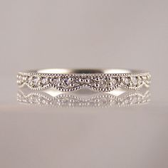 a white gold wedding ring with diamonds on it's sides and in the middle