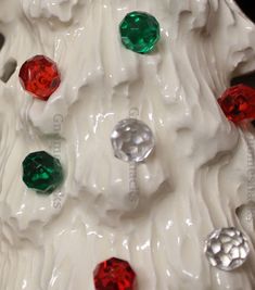 a white christmas tree with red, green and silver ornaments on it's side