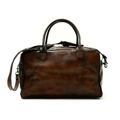 Handcrafted in soft leather and hand polished for a vintage patina, the John Woodbridge Weekend Bag will be your faithful companion for a quick getaway or your trips to the gym. This cabin-sized model is ready to hop on a plane whenever you are. For all you boxers out there: It has room enough to fit your boxing gloves. - Dimensions : 50 x 25 x 25 cm - One pocket with zip closure - One pocket for your phone/passport - Cotton-lined interior - Removable, adjustable leather strap with brass hardwar Classic Leather Travel Bag For Trips, Classic Leather Lined Satchel For Trips, Classic Satchel With Leather Lining For Trips, Vintage Waxed Travel Bag For Everyday Use, Brown Waxed Finish Satchel For Travel, Classic Waxed Finish Shoulder Bag For Travel, Classic Travel Shoulder Bag With Waxed Finish, Brown Soft Leather Bag For Overnight Trips, Classic Waxed Satchel Duffle Bag