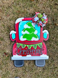 a cardboard christmas truck with a tree on the front and bottom, sitting in grass