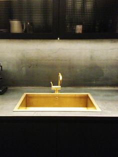 a yellow sink sitting in the middle of a counter top next to a black cabinet