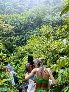 two women in bikinis walking through the jungle