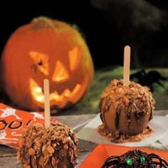 halloween treats are on display with pumpkins and candy sticks in the foreground, along with two jack - o'- lanterns