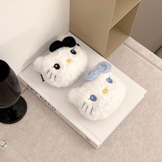 a pair of hello kitty slippers sitting on top of a book