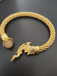 Naga Snake Bracelet Thai Amulet Brass Coated Magic Serpent Money Rich Good Charm Guru Monk create this amulet as love charm amulet.  Carry out will make people fascinated with you. Materials = Mixed Colour = Gold Quantity : 1 pcs Length :20 cm.  Inner diameter: 6 cm. (Can be flexible in and out) Shipping Information & Return Policy. Handling time 2-3 business days FREE Shipping handling to WORLDWIDE via THAILAND POST with TRACKING NUMBER, The packet will take about 14-20 business days.   *100% S Symbolic Gold Jewelry For Blessing, Spiritual Gold Bracelet, Gold Blessing Jewelry, Gold Round Jewelry For Blessing, Gold Spiritual Charm Bracelet, Handmade Symbolic Gold Charm Bracelet, Symbolic Handmade Gold Charm Bracelet, Symbolic Gold Bracelet Jewelry, Spiritual Style Chain Bracelet