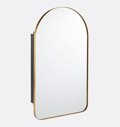 an oval mirror mounted on the wall with a black frame and gold trim around it