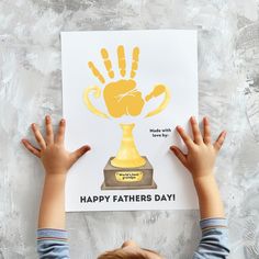 a young boy holding up a card with the words happy fathers day written on it