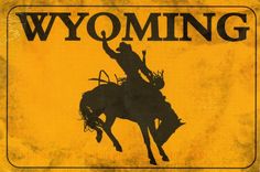 a yellow and black wyoming sign with a cowboy riding a bucking horse