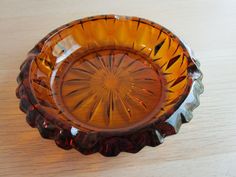 an orange glass bowl sitting on top of a wooden table