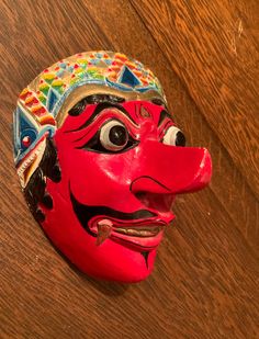 A vibrant and striking mask! Great colors. Elaborate detail. A wood carved mask for Javanese dance. Mask maker Ganuh Nugroho AdiNarimo is highlighted in an article (Javanese Klana 5/25/2017) in Second Face at maskmuseum.org Klana Sewandana (character) is the male antagonist in a love dance. In good condition with some minor chipping as shown in the photos. Enjoy! Traditional Masks And Prosthetics For Carnival, Artistic Red Masks And Prosthetics For Festivals, Traditional Carnival Masks And Prosthetics, Traditional Masks And Prosthetics For Masquerade Festivals, Traditional Full Face Carnival Masks, Traditional Festival Masks And Prosthetics, Traditional Masks For Masquerade And Festivals, Handmade Traditional Mask, Carved Mask