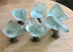 four glass knobs are sitting on a wooden table