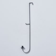 a metal hook on the side of a white wall