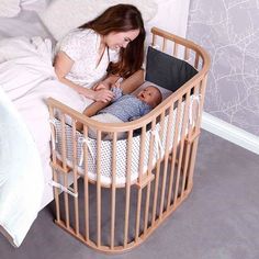 a woman laying in bed next to a baby