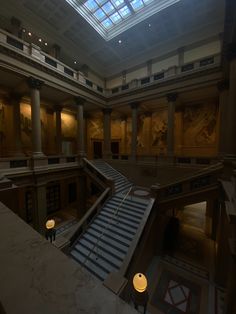 an empty building with stairs leading up to the second floor and skylight above it