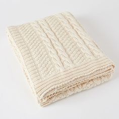 a white knitted blanket laying on top of a table