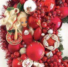 an assortment of christmas ornaments arranged on top of red tinseled balls and garlands