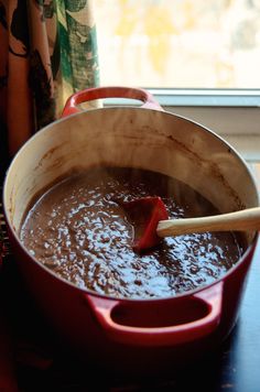 a pot filled with brown liquid sitting on top of a table next to a window