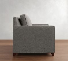 a gray couch sitting on top of a wooden floor