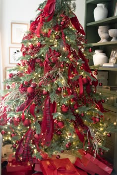 a decorated christmas tree with red bows and ornaments