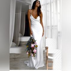 a woman in a white dress holding a bouquet of flowers