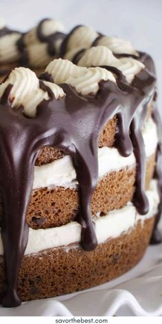 a cake with white frosting and chocolate drizzled on it's top