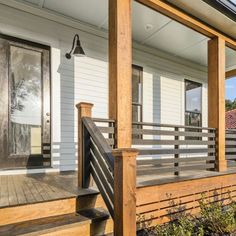 the front porch of a house with wooden steps and railings on either side of it