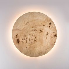 a round wooden object with holes in the center on a white wall mounted above it