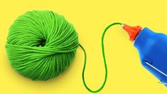 a green ball of yarn next to a blue spool of thread