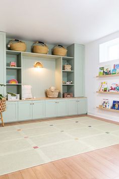 a living room with blue cabinets and bookshelves filled with children's toys