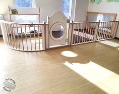 an empty room with wooden floors and a dog gate on the floor in front of it