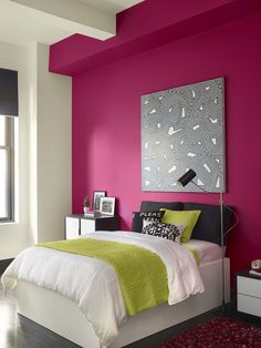 a bedroom with bright pink walls and white bedding, black and green accents on the headboard