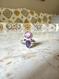 In bloom ring is set with a rose cut ruby, opal and two blue sapphires made in sterling silver. Opal has a pink and blue flash. Ruby has a wonderful opaque glisten and the cut gives it a little sparkle, nestled with the blue sapphires and opal it really sets it off.  US size 6 - can be sized up a bit Pink Sterling Silver Opal Ring For Anniversary, Pink Opal Ring In Sterling Silver For Anniversary, Pink Moonstone Sterling Silver Ring For Anniversary, Pink Sterling Silver Moonstone Promise Ring, Handmade Pink Ruby Ring In Sterling Silver, Unique Pink Multi-stone Rings, Pink Opal Sterling Silver Ring Gift, Pink Opal Ring In Sterling Silver For Gift, Unique Handmade Pink Ruby Ring