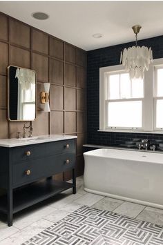 a bath room with a tub a sink and a mirror on the wall next to a window