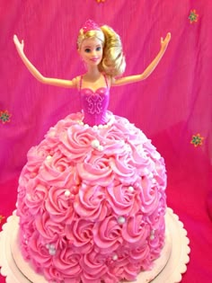 a barbie doll cake with pink frosting on it's face and arms in the air