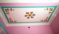 the ceiling is painted pink and blue with flowers on it, along with other decorations