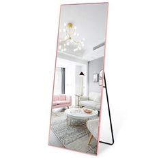 a mirror that is on the ground in front of a white couch and coffee table