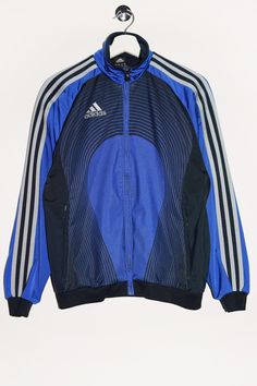 "Vintage Adidas track jacket in blue with a print on the back. - Size tag: Please always check measurements before buying. Youth size L, Fits like Women's S - Measurements (laying flat): Pit to Pit: 21\" Length: 24.5\" Pit to Cuff: 20\" -Wear: /Please see images for details/ Good vintage condition. Fabric snag and burnt spot looking like light stain as shown on the pictures. - Fabric: Polyester *All of our items are preloved pieces so some signs of natural wear and age are to be expected. Please look through the photos carefully to check if the condition is to your satisfaction. *All efforts are made to show any defects however small imperfections may be missed. In cases that we've missed a major flaw, please remember that we are still human and make mistakes, please contact us first so we Vintage Blue Adidas Jacket, Blue Athleisure Outerwear With Three Stripes, Blue Sports Windbreaker, Blue Sportswear Outerwear With Three Stripes, Blue Sportswear Track Jacket For Fall, Blue Track Jacket For Fall Sportswear, Blue Streetwear Outerwear With Three Stripes, Blue Track Jacket For Fall, Blue Stripe Outerwear For Streetwear