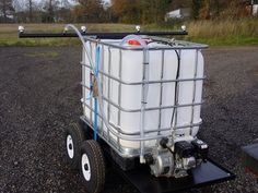 a cart that is sitting in the gravel with some containers on it's wheels