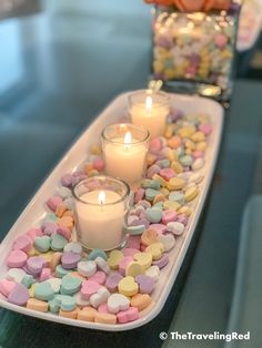 two trays filled with marshmallows and candles on top of a table