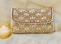 Thank you so much for visiting my shop ! **Handcrafted White and Gold Beaded Clutch - Radiant Elegance** Make a statement with this **handmade whit and  gold clutch with zardozi  featuring intricate beadwork that shimmers with every step you take. The soft, warm tone of rose gold paired with an exquisite **scalloped design** makes this clutch a must-have accessory for any elegant occasion. Whether it's a wedding, gala, or evening out, this piece adds a touch of glamour to any outfit. - **Color Stunning white and gold with delicate sparkle - **Design Intricately hand-beaded in a timeless scalloped pattern - **Material High-quality fabric embellished with fine beadwork for a luxurious feel - **Size Compact yet roomy enough for your essentials like a phone, cards, and makeup A perfect blend o Gold Wedding Clutch With Zari Work, Gold Clutch With Zari Work For Wedding, Traditional Gold Clutch With Pearl Embroidery, Gold Zari Work Wedding Clutch, Festive Gold Clutch With Zari Work, Party Clutch With Gota Work, Gold Hand Embellished Clutch For Wedding, Gold Evening Bag With Handwork For Reception, Wedding Gold Clutch Hand Embellished