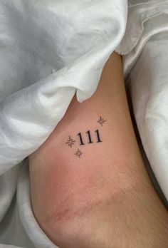 a person with a small tattoo on their leg that reads 11 11 and has snowflakes all over it