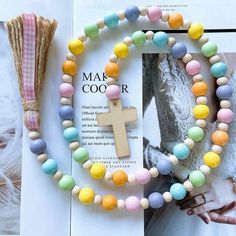 the colorful beads are on display next to a book and tassell with a cross