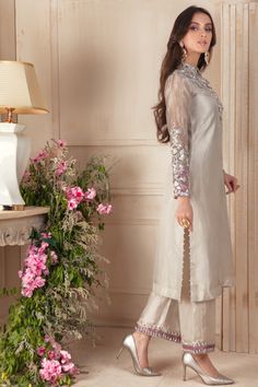 Pearl White Indian tissue shirt featuring 3D floral embroidery with tila, resham, silver dabka, crystals & stones, pearl and multi-shade sequins, over collar & neckline, color block embroidered sleeves & matching culottes. This elegant & modern ensemble is finished with hand embellished embroidered net dupatta. Shirt & Culotte Fabric: Pure Indian Tissue Shirt Length: 45” Dupatta Fabric: Embroidered Net Shirt & Culotte Color: Pearl White Dupatta Color: Mauve All outfits are fully lined Lining in Nikah Dresses, Punjabi Dress Design, White Dupatta, Nikah Dress, Womens Pants Design, Pakistani Designer Clothes, Muslin Dress