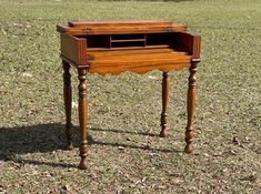 an old wooden desk sitting in the grass