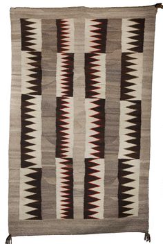 an old navajo rug with brown, white and black designs on the front end is shown