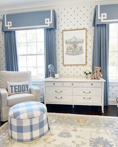 a baby's room with blue and white decor, including a teddy bear on the dresser