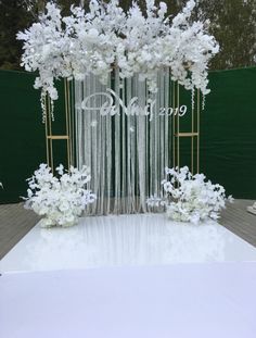 a white wedding ceremony decoration with flowers