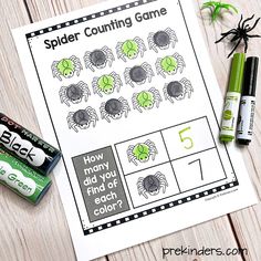 a spider counting game with two batteries and some crayons on the table next to it